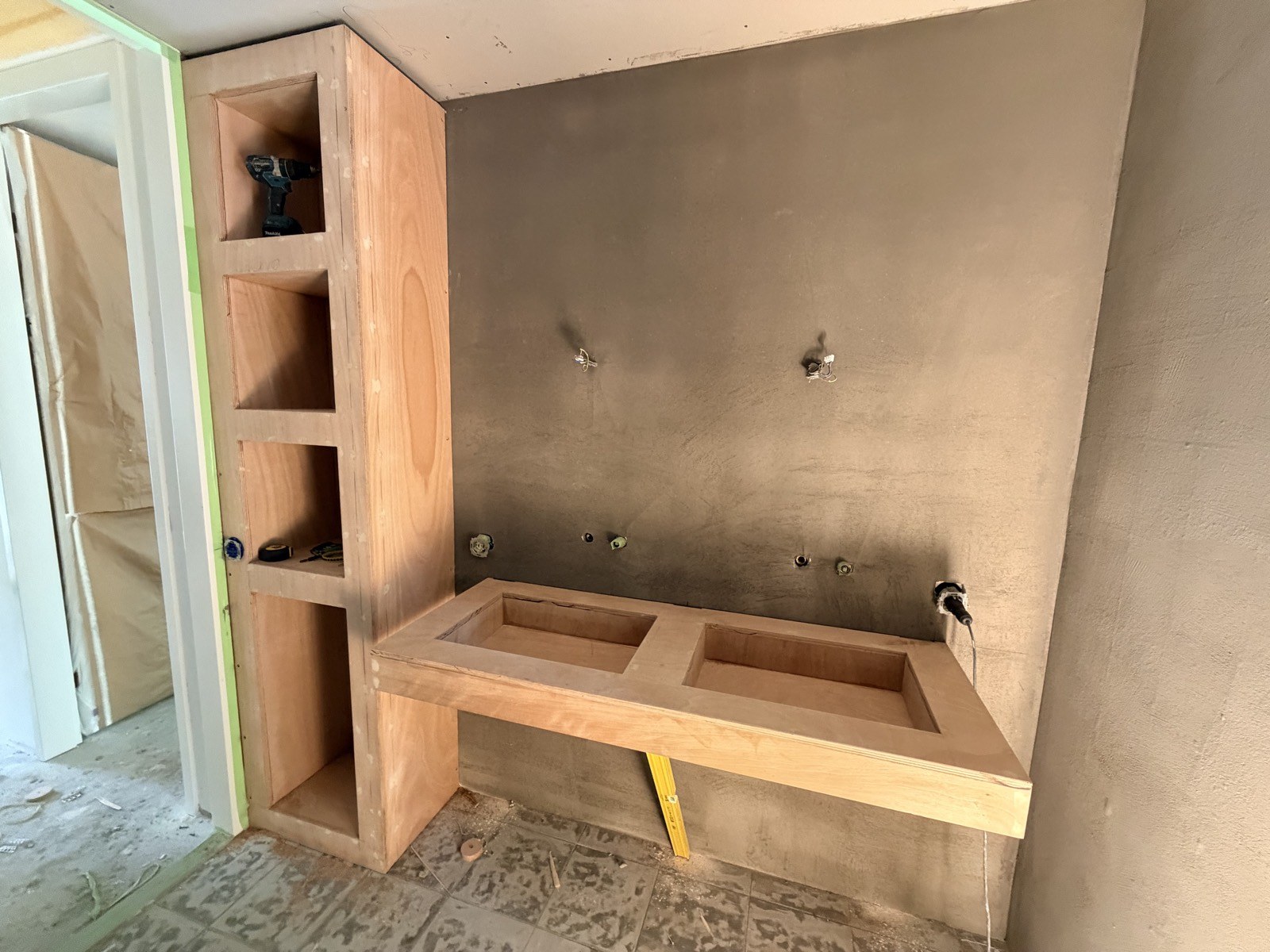 Op maat gemaakt badkamermeubel in aanbouw tegen een wand van microcement