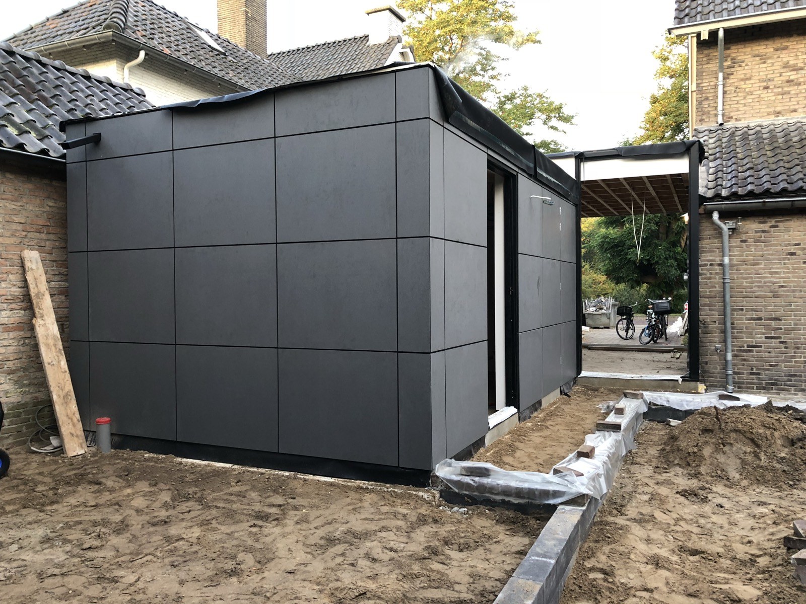 Modern bijgebouw met grote gevelplaten in betonlook