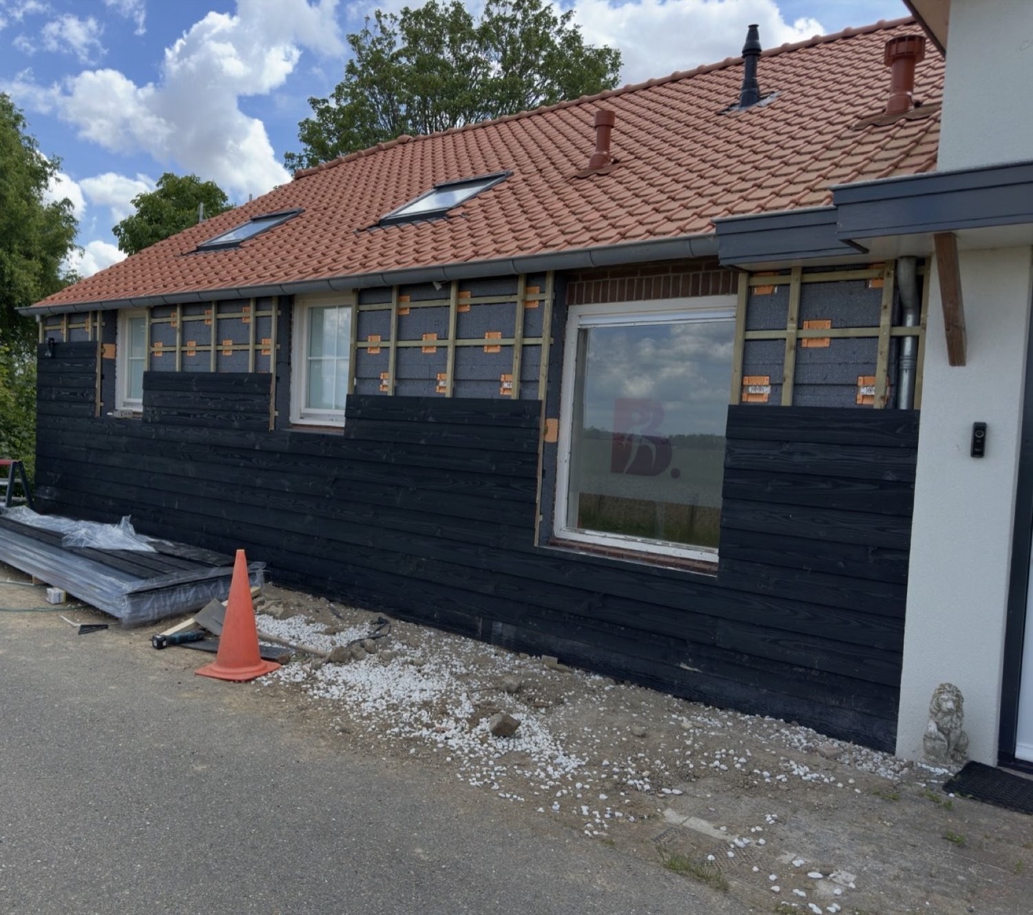 Gevelrenovatie met zwarte houten rabatdelen over nieuwe isolatie