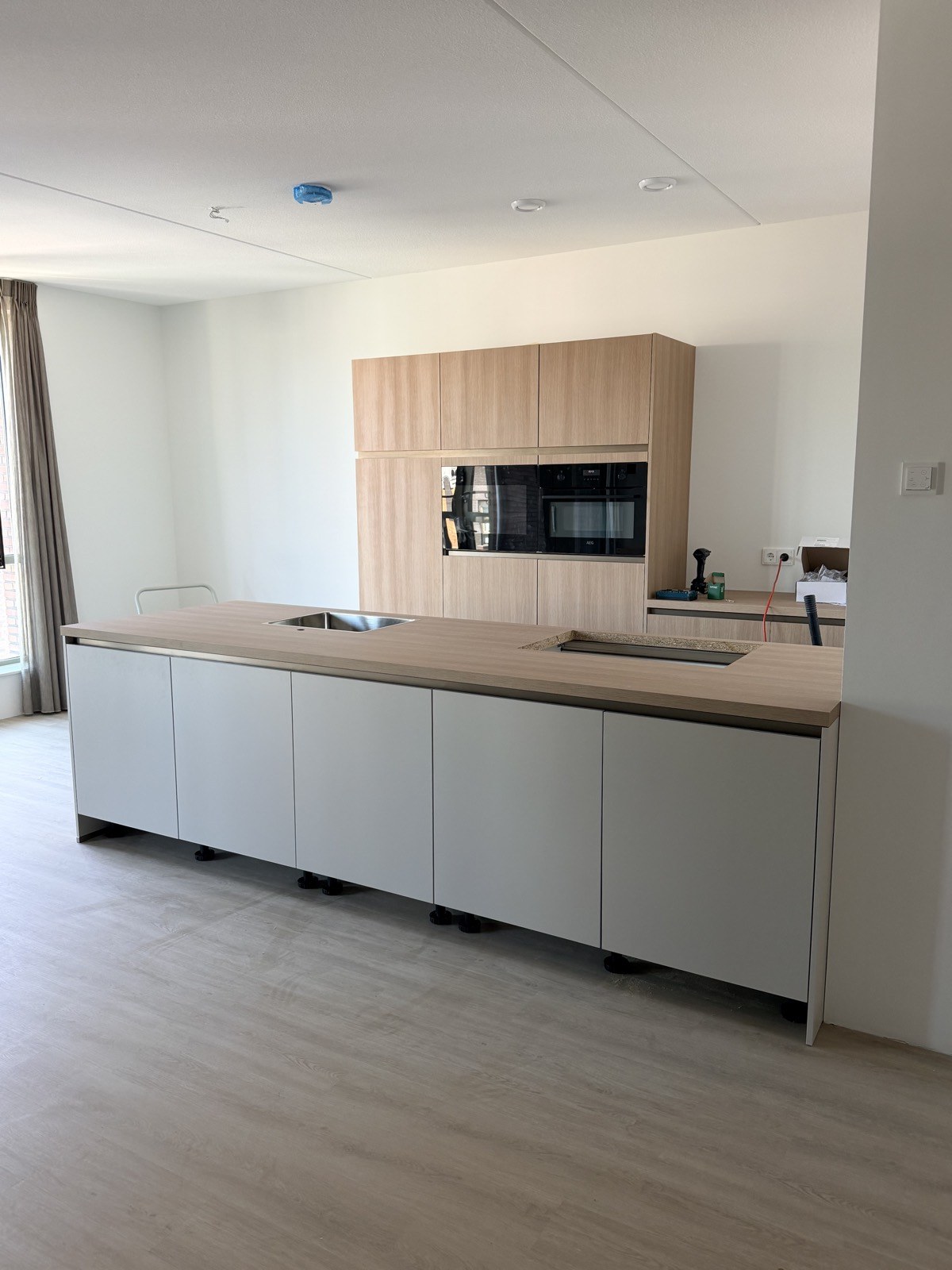 Lichte keuken met een lang eiland en houten fronten