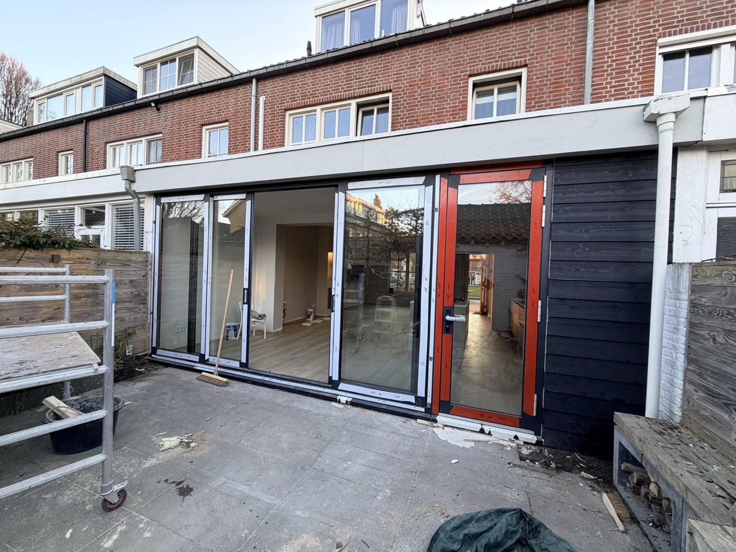 Uitbouw van een woning met schuifpui en zwarte houten gevelbekleding