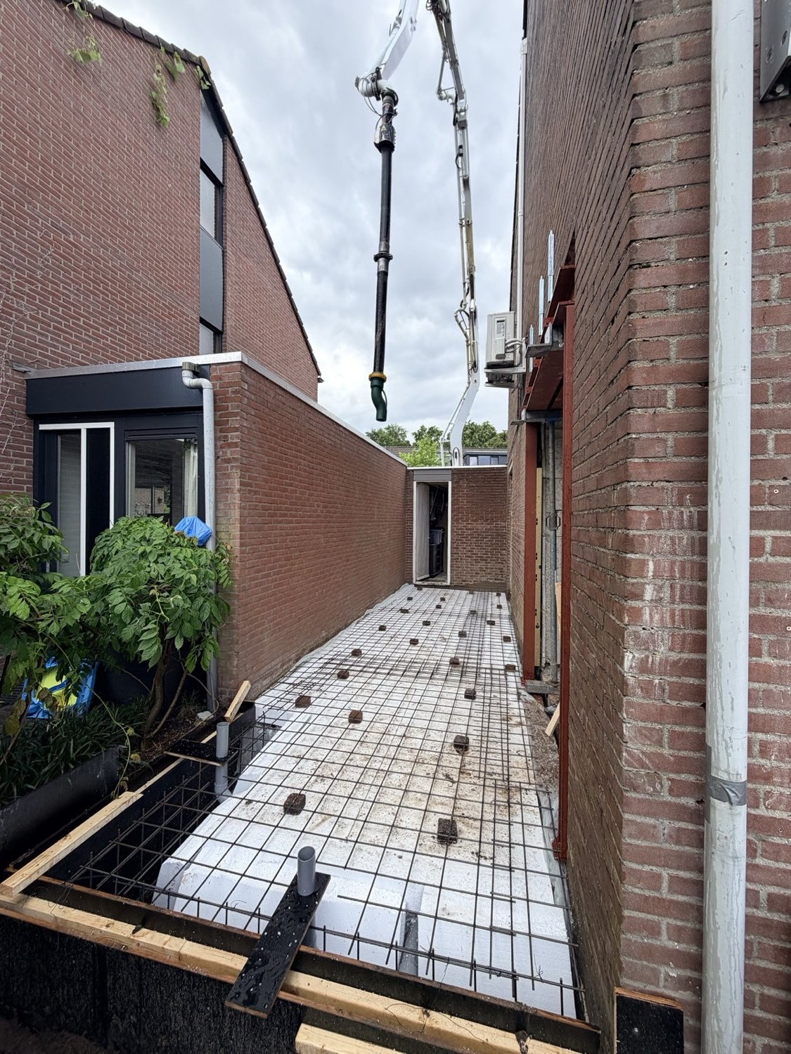 Betonvloer met wapeningsnet wordt gestort voor een uitbouw